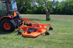 Land Pride FDR25 series grooming mower behind a Kubota tractor with a cab, on a lawn by a stand of trees