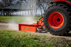 Land Pride GS15 series grading scraper raising dust on a gravel drive behind a Kubota tractor, close up