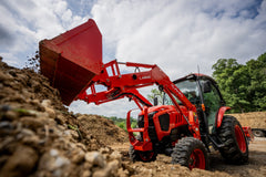 Kubota L3970 ProCab dumping a loader bucket of soil onto a pile