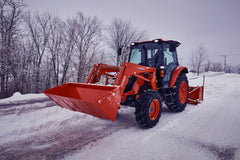 Kubota M4 series cab tractor with a front loader and a rear snowblower on a snowy road