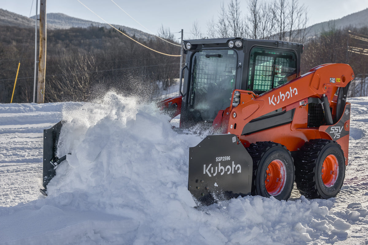 Kubota SSV75 skid steer pushing snow with a Kubota SSP2596 snow pusher