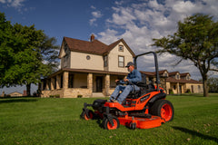 Kubota ZD1211 zero-turn mower on a farmhouse lawn