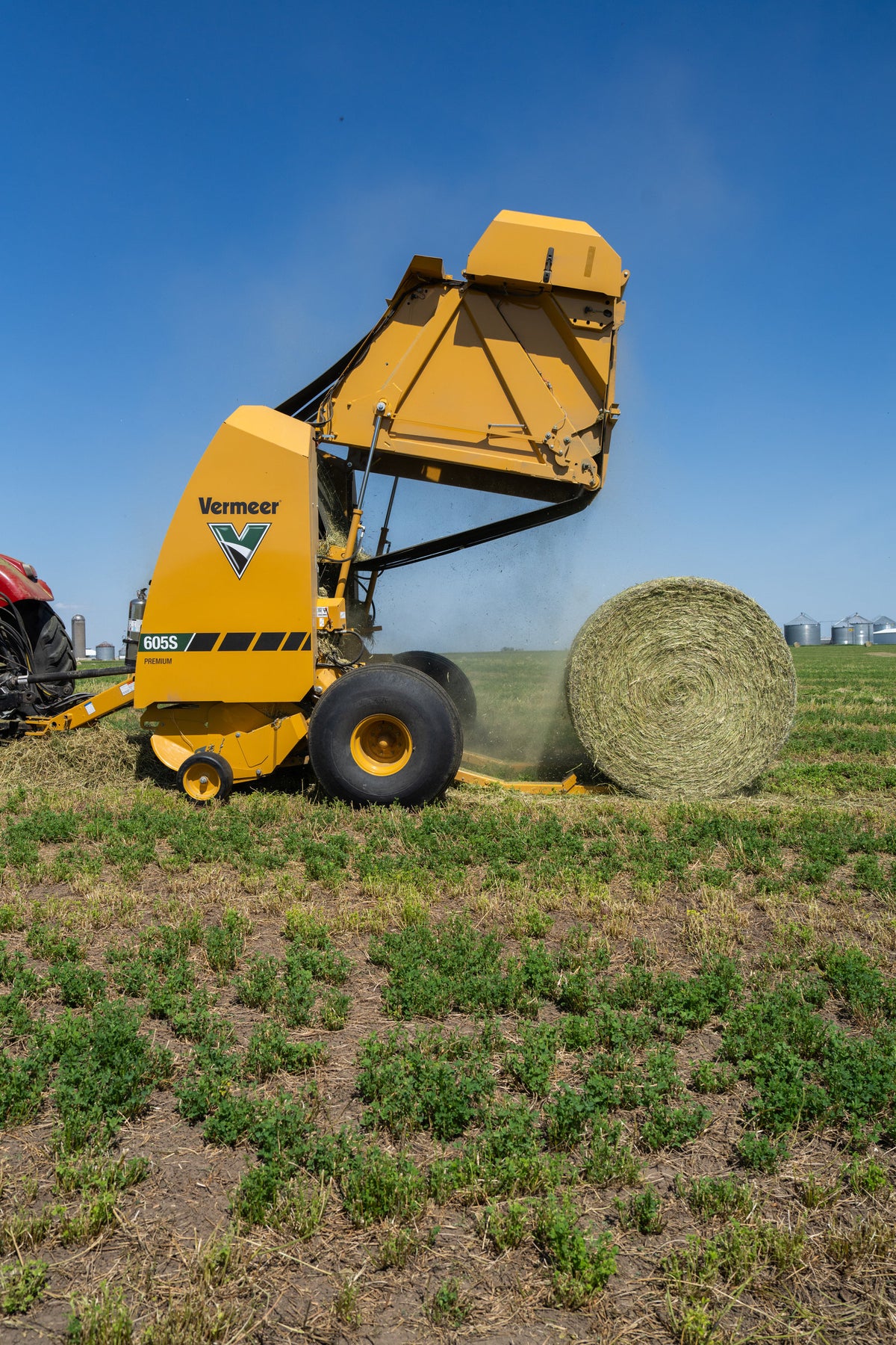 Vermeer 605S Premium round baler with tailgate open ejecting a bale