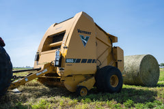 Vermeer 605S Premium round baler beside a finished bale
