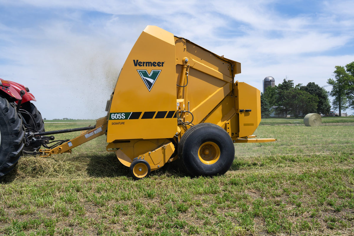Vermeer 605S Signature round baler baling hay behind a tractor