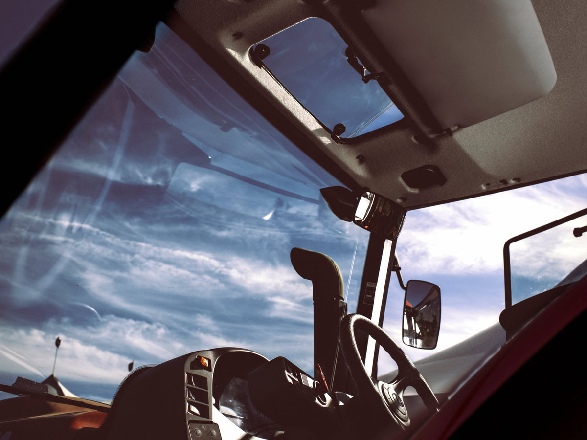 The view from the driver's seat of a Kubota M6 cab tractor: the windshield, roof window and steering wheel