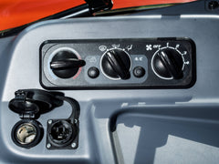 Climate controls and power sockets in a Kubota M6 tractor cab, close up