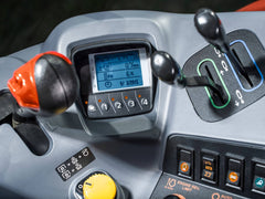 The armrest controls and display in a Kubota M6 tractor cab, close up