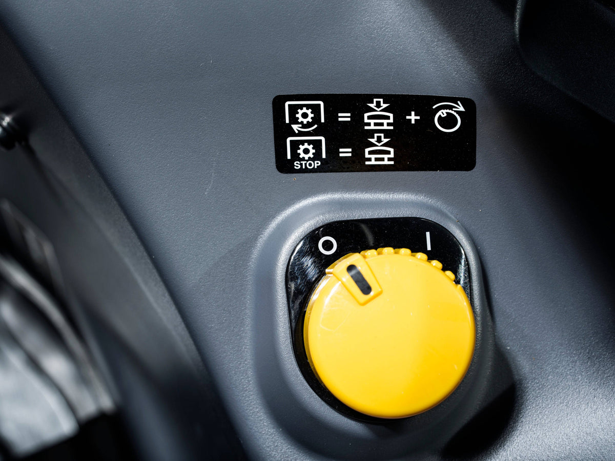 A yellow PTO control knob in a Kubota M6 tractor cab, close up