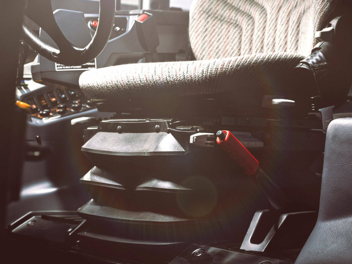 The seat and its controls in a Kubota M6 tractor cab, close up