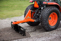 A Land Pride RB1672 rear blade angled to grade a gravel drive behind a Kubota tractor, close up