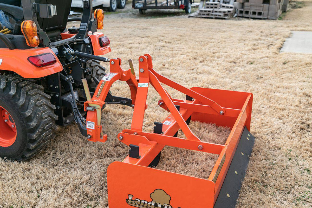 A Land Pride QH05 quick hitch connecting a Land Pride box scraper to a Kubota sub-compact tractor