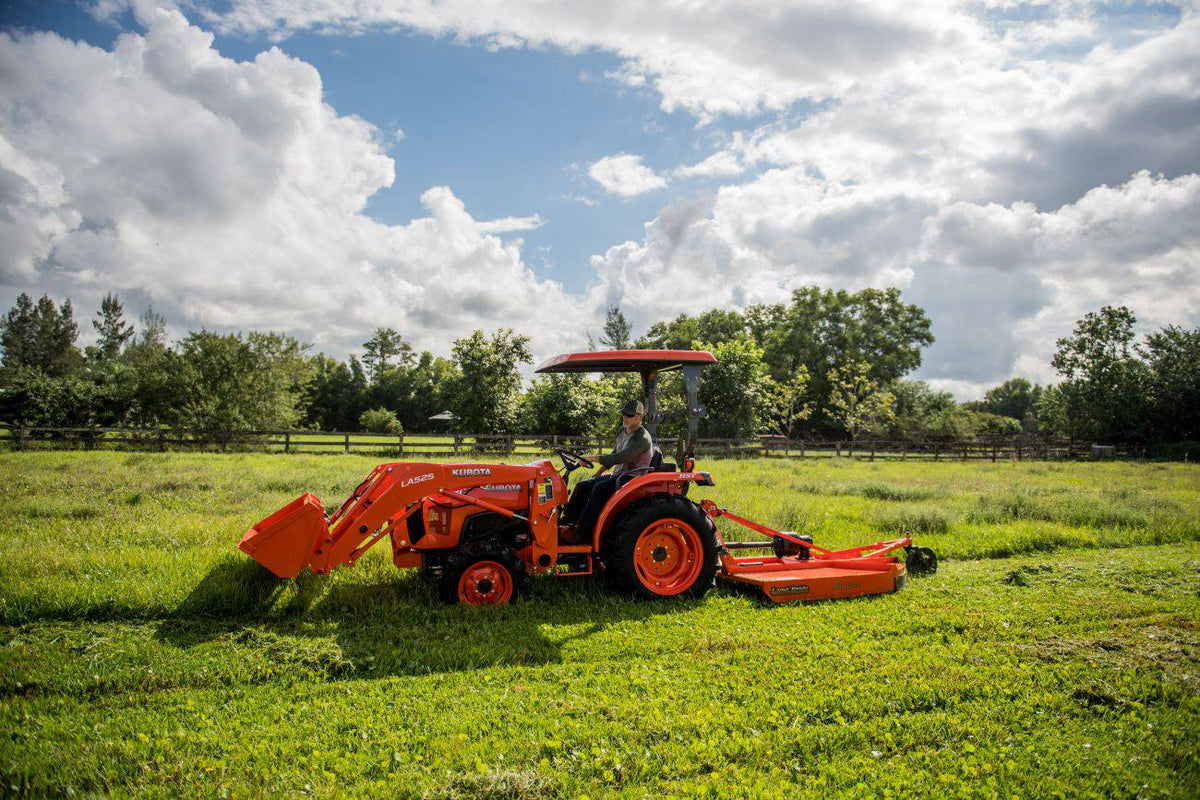 Kubota tractor with a canopy and a front loader mowing a field with a Land Pride RCR12 series rotary cutter